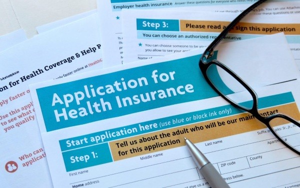 Stack of papers entitled Application for Health Insurance