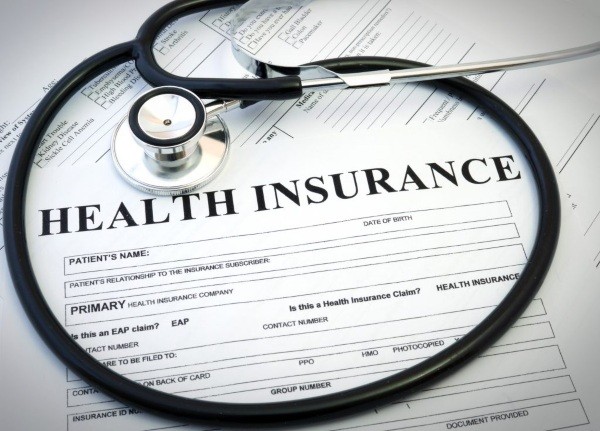 Stethoscope on stack of health insurance documents