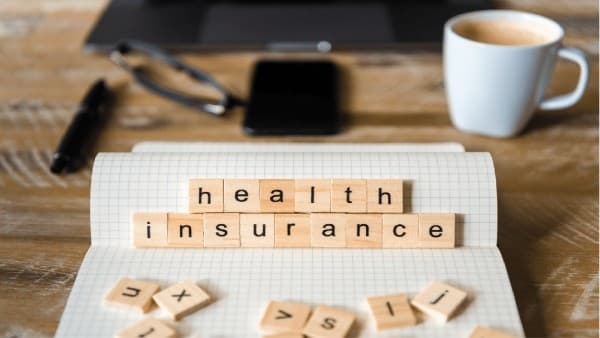 Wooden letter tiles spelling out _health insurance_