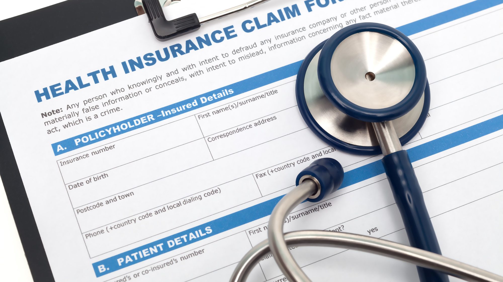 Close-up of health insurance claim form with stethoscope on top