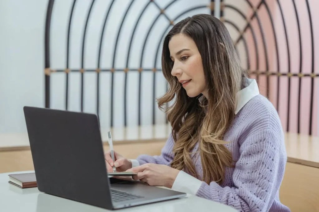 Self-employed woman working on a laptop while reviewing health insurance cost options