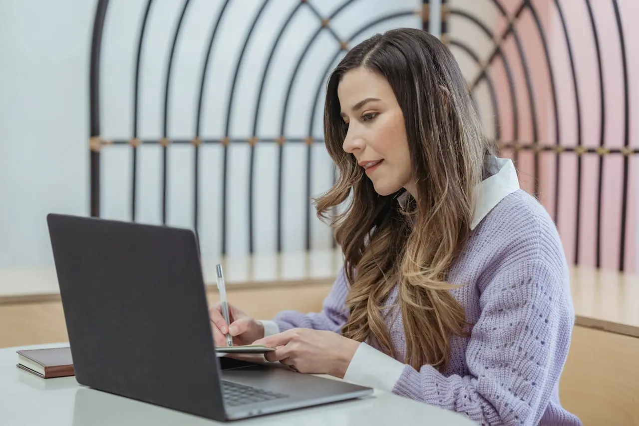Self-employed woman working on a laptop while reviewing health insurance cost options