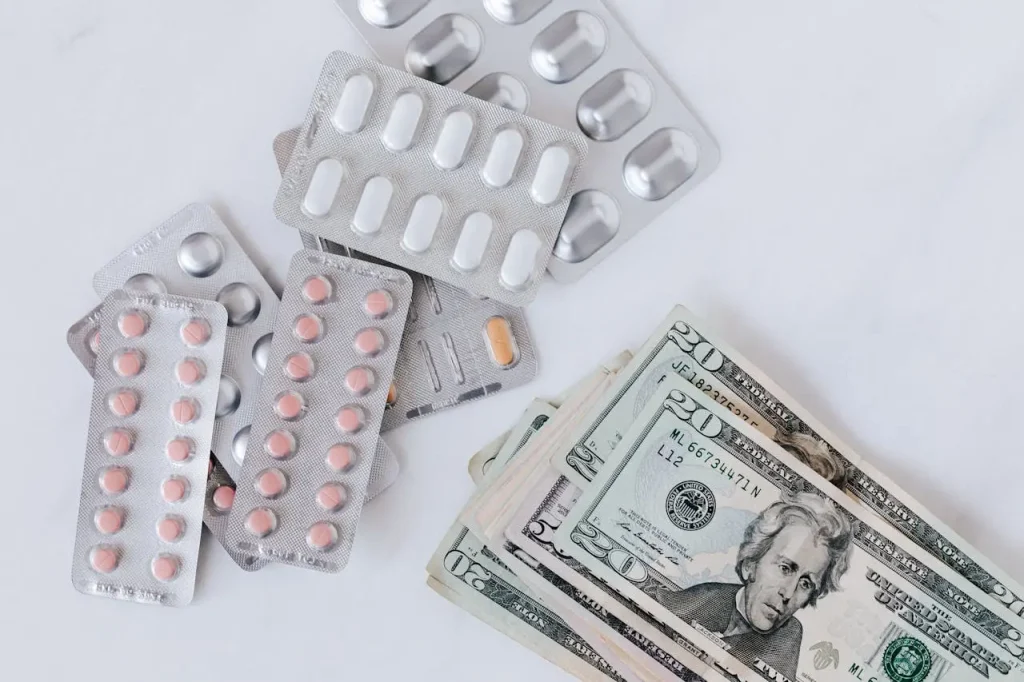 Prescription blister packs and cash representing medical expenses and health insurance alternatives
